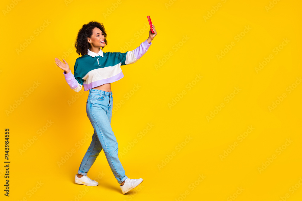 Full size photo of cheerful woman dressed striped top make selfie on smartphone walk to empty space isolated on yellow color background Full size photo of cheerful woman dressed striped top make selfie on smartphone walk to empty space isolated on yellow color background