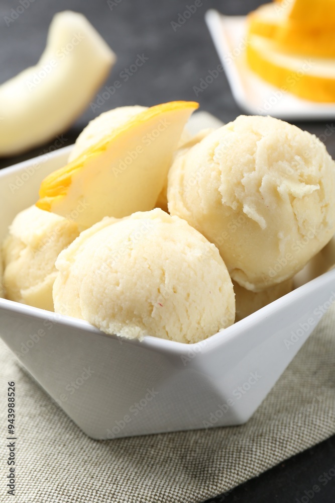 Scoops of tasty melon sorbet with fresh fruit in bowl on grey table, closeup Scoops of tasty melon sorbet with fresh fruit in bowl on grey table, closeup
