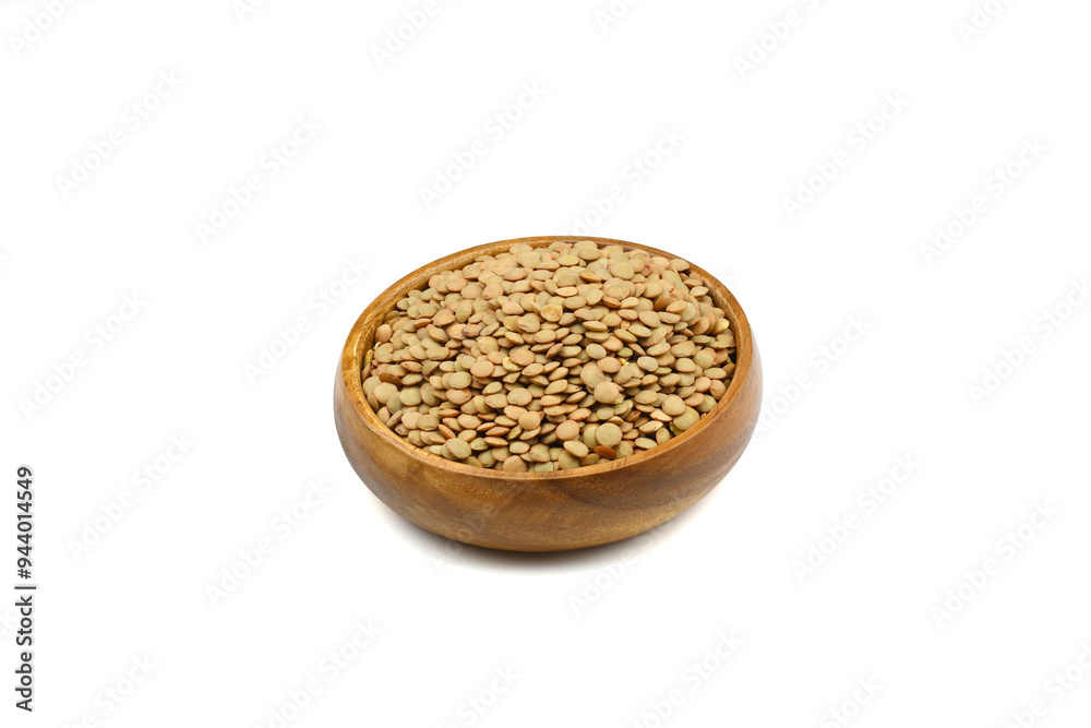Green lentils in wooden bowl on isolated white background. Top view, copy space. Flat lay. Green lentils in wooden bowl on isolated white background. Top view, copy space. Flat lay.