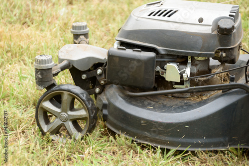 man cutting the grass with black lawnmower