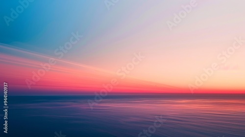 A stunning gradient of sunset colors spreads across the sky, with deep reds and soft pinks blending seamlessly into the twilight blue.