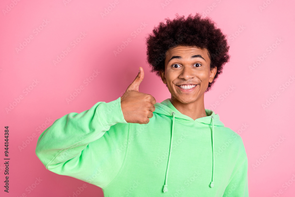 Portrait of nice young man show thumb up wear green hoodie isolared on pink color background Portrait of nice young man show thumb up wear green hoodie isolared on pink color background