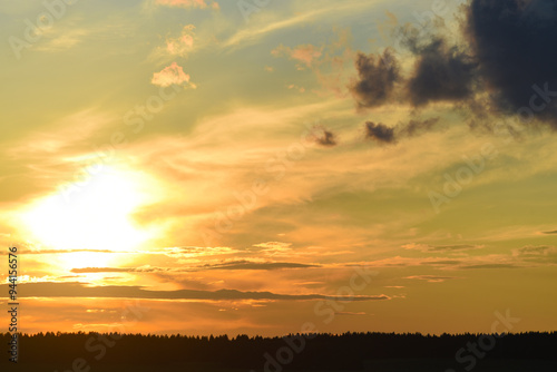 Beautiful sunset landscape with red clouds. Evening horizon with a forest.