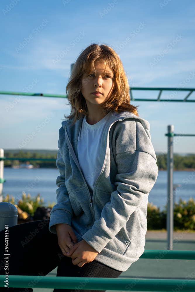 Teen girl portrait outdoors, child posing at city sports ground and looking away Teen girl portrait outdoors, child posing at city sports ground and looking away