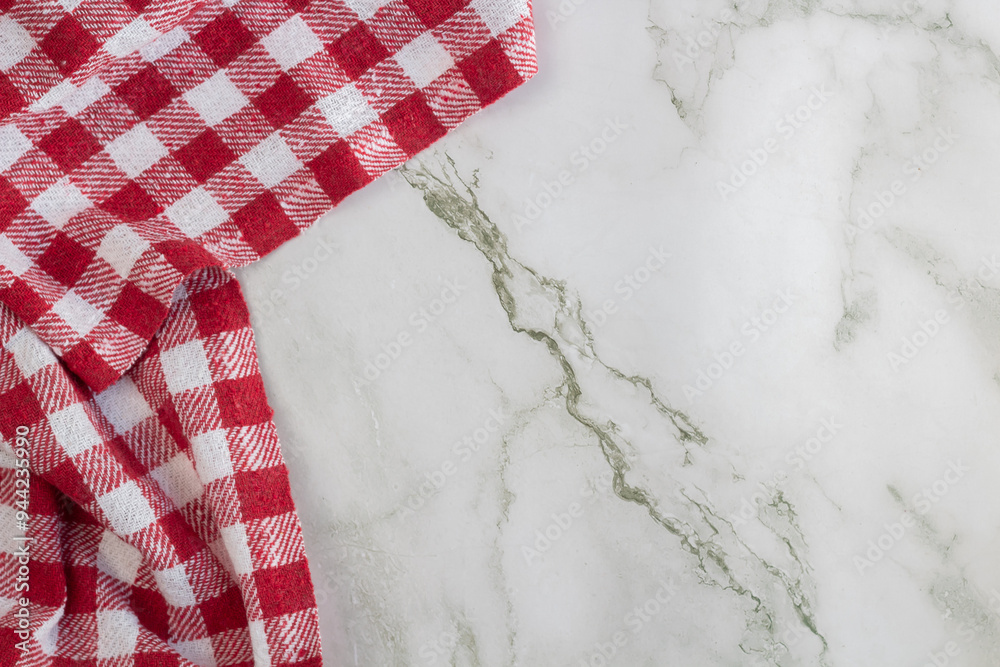 Fototapeta premium Red and white checked napkin on the left side, on a marble surface