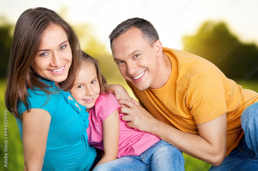 Cheerful young family sitting on the park. Cheerful young family sitting on the park.