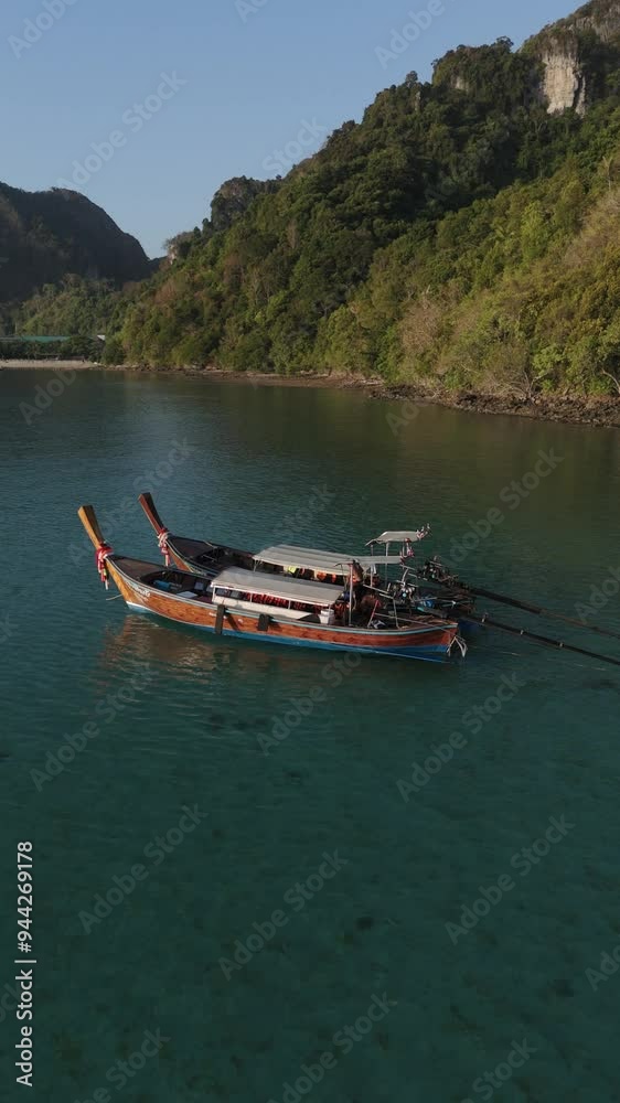 Traditional Thailand fishing boat navigating calm waters near Koh Phi Phi Island lush green hills during early morning light
