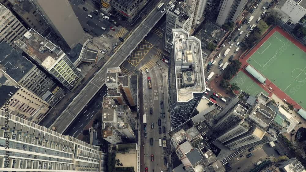 City, buildings and cars on highway from drone in Hong Kong with traffic or travel in development. Cityscape, road and infrastructure downtown with architecture, grid and rooftop of skyscraper