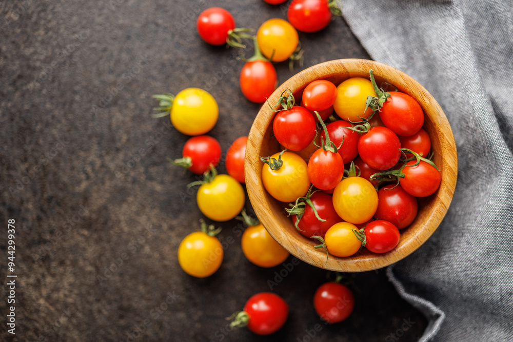Different colorful cherry tomatoes in bowl. Top view.