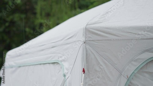 Close-up shot of a tent wile raindrops falling on it's roof
