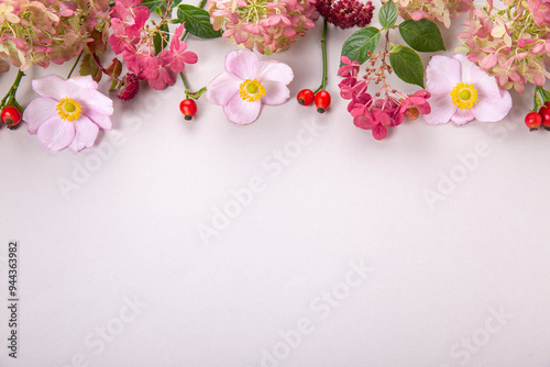 Autumn flowers composition purple hydrangea, pink anemone, rose hips on gray background. Autumn, fall wedding, holiday concept. Flat lay, top view