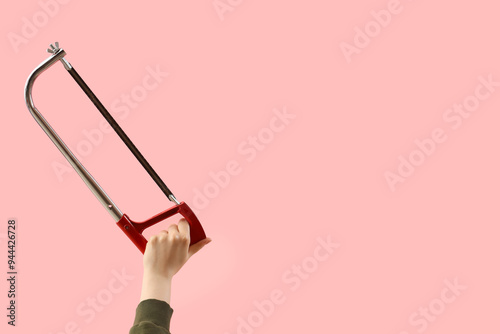 Female hand holding hacksaw...