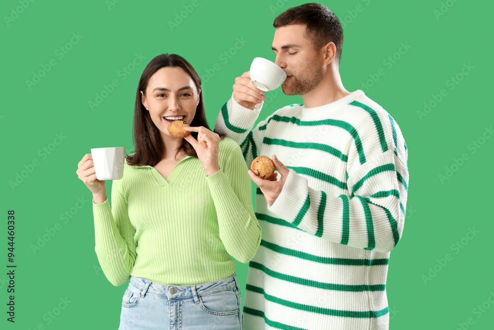 © Pixel-Shot - Young couple with cookies drinking tea on green background © Pixel-Shot - Young couple with cookies drinking tea on green background