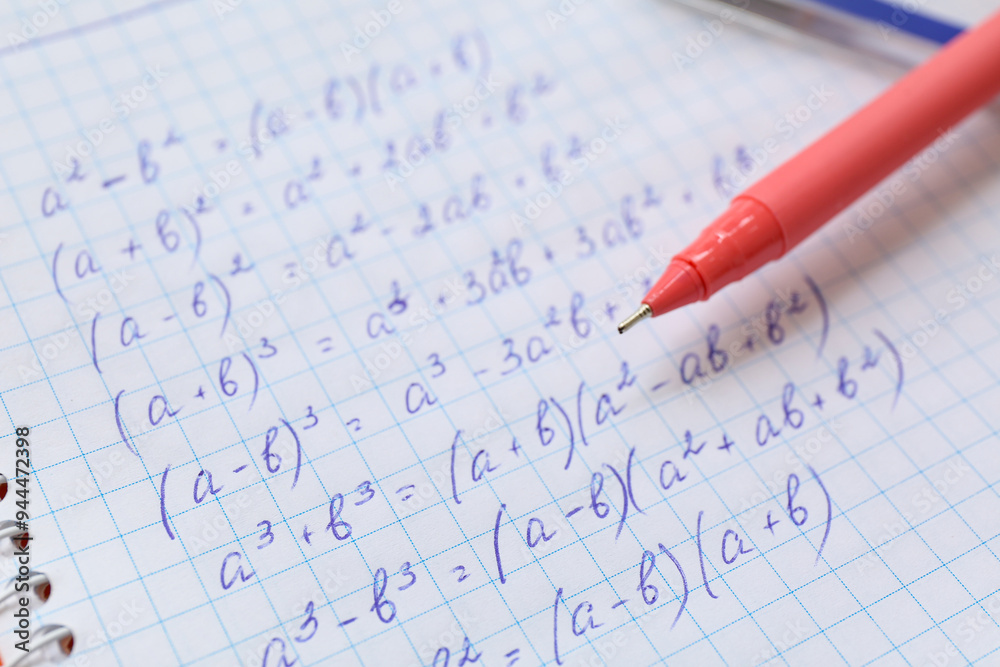 Notebook with written math equations and pen, closeup Notebook with written math equations and pen, closeup