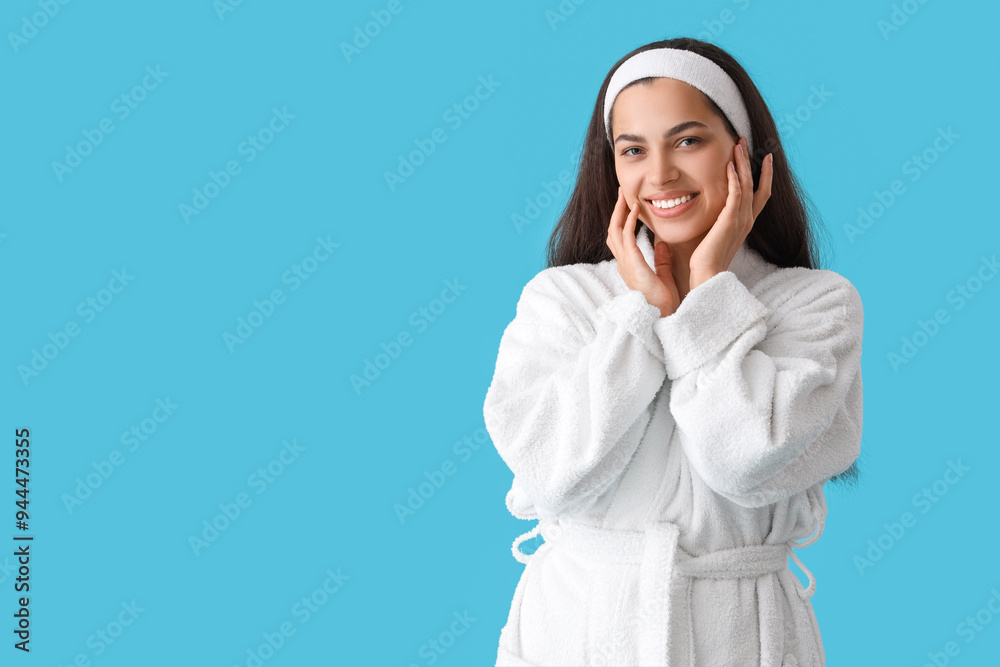 Beautiful young happy woman in bathrobe on blue background Beautiful young happy woman in bathrobe on blue background