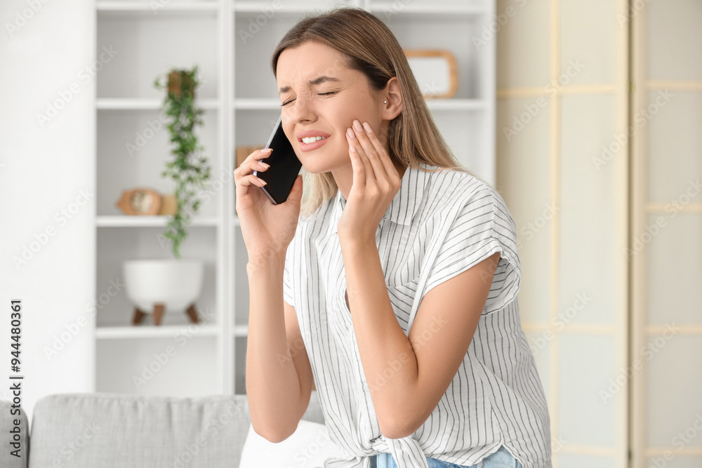 Young woman with tooth ache talking by phone at home Young woman with tooth ache talking by phone at home