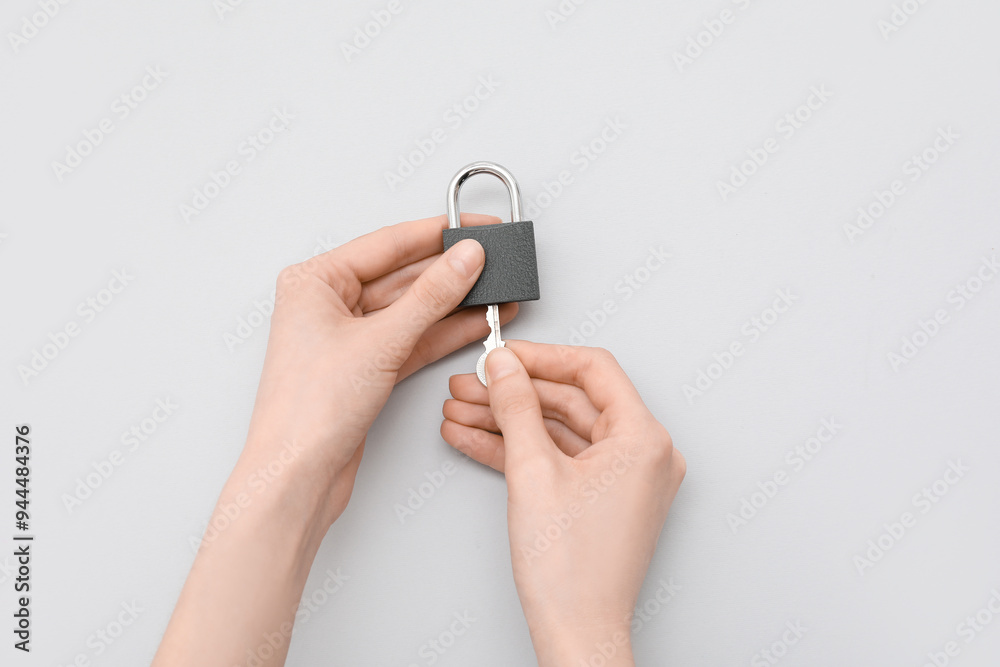 Hands with padlock and key on grey background Hands with padlock and key on grey background