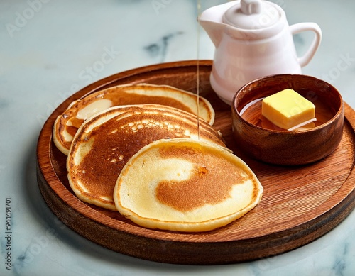 Traditional Norwegian sveler (pancakes) served with butter and syrup on a wooden plate - traditional norwegian dish photo