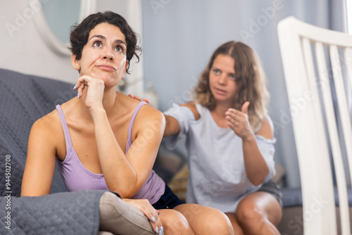 Displeased woman and her female companion, purse lips with displeasure, have quarrel and bad relationships