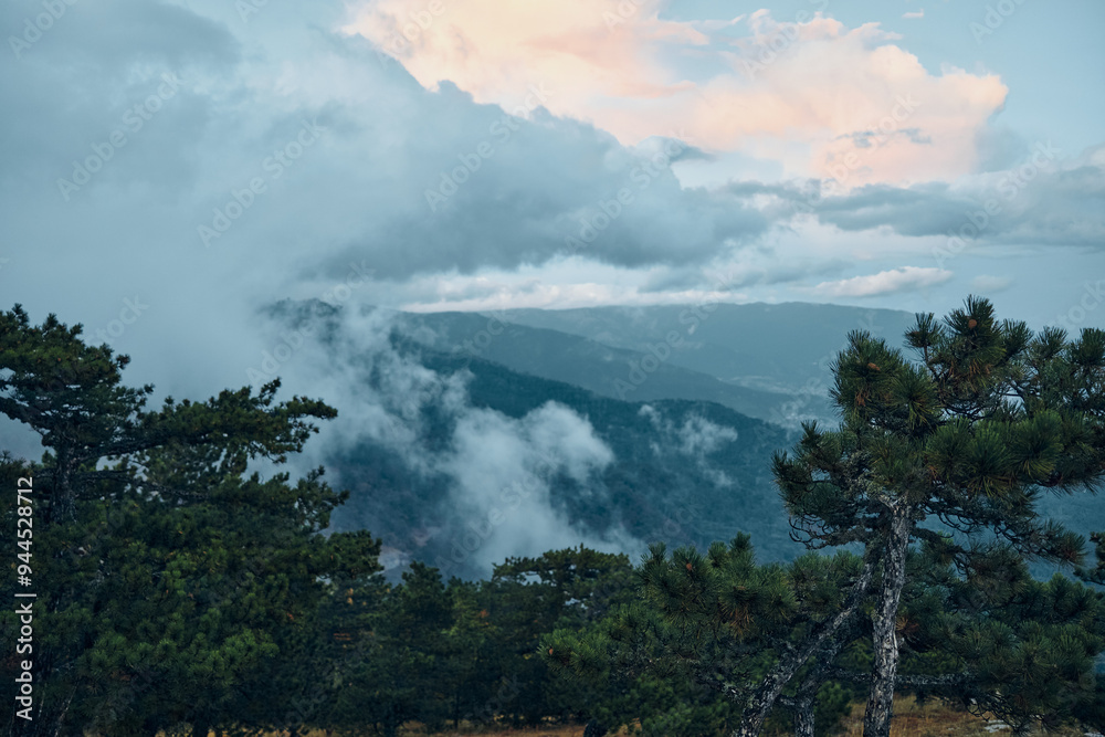 Fototapeta premium Scenic Mountain View with Clouds and Trees in the Foreground Serenity and Beauty of Nature Landscape Travel Inspiration