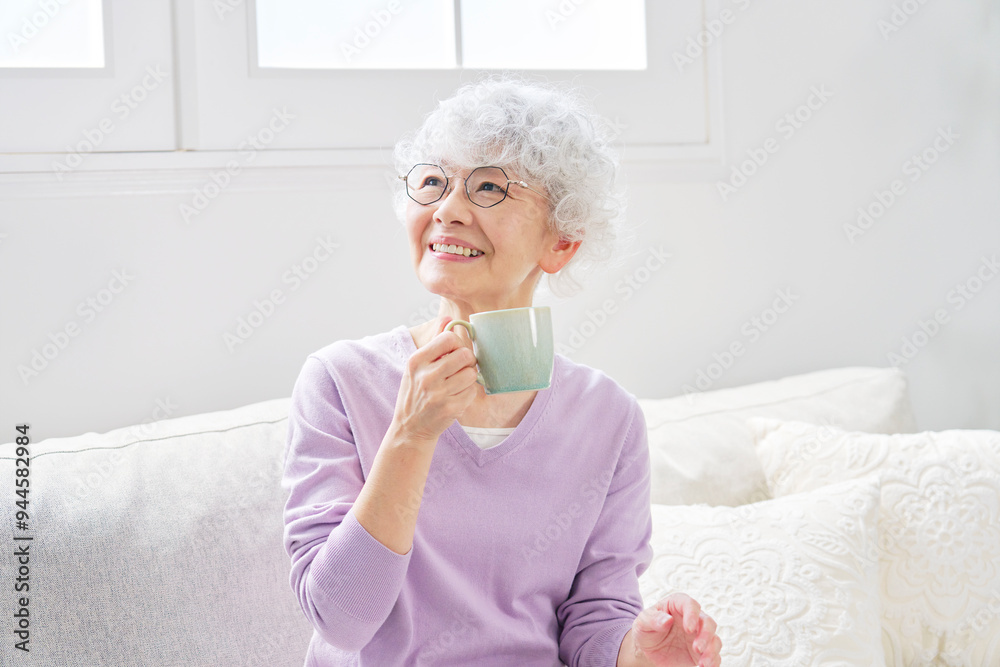 リビングルームでリラックスするシニア女性のポートレート