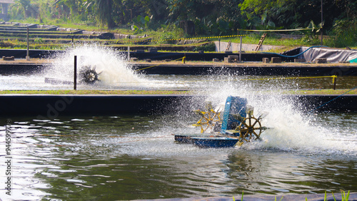 A dynamic shot of a paddle wheel aerator splashing water in a fish farming pond, showcasing sustainable aquaculture technology and its benefits