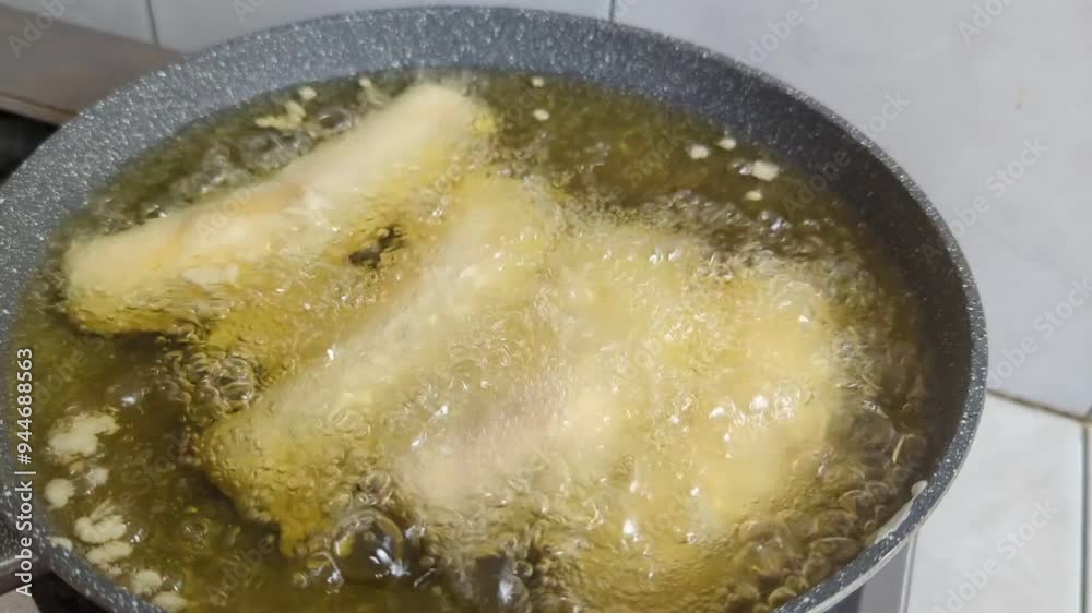 Cooking banana covered with flour being deep fried on hot oil in frying pan or skillet, High quality 4k footage Cooking banana covered with flour being deep fried on hot oil in frying pan or skillet, High quality 4k footage