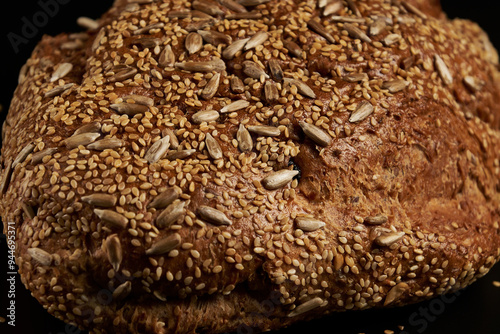 Artisanal bread made and baked at home with multigrain seeds on a dark background, a healthy product to enjoy with the family.