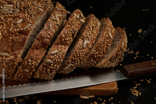 Artisanal bread made and baked at home with multigrain seeds on a dark background, a healthy product to enjoy with the family. photo