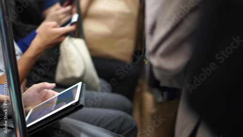 No face pov passenger playing phone and pad social media on train transportation in Asia