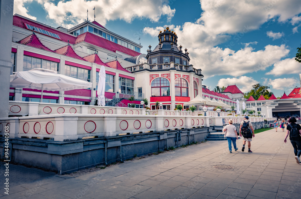 Naklejka premium Bright summer view of modern buildings in Dolny Sopot resort. A lots of tourists walking in outskirts of popular tourist destination - Sopot Pier (Molo in Sopot), Poland. Vacation concept background..