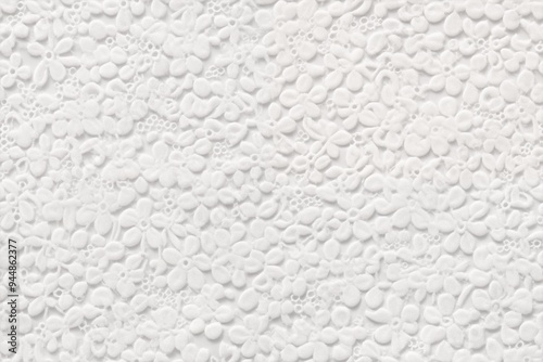 Cotton broderie anglaise texture. Textured background featuring a pattern of small white flowers and floral shapes, creating a delicate and intricate design.