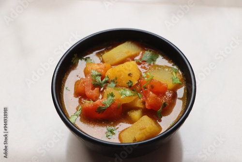 Tomato Batata Rassa Bhaji, tangy curry made with tomato, potato, cononut and spices, dish from Konkan Maharashtra, India, served with rice or flat bread photo