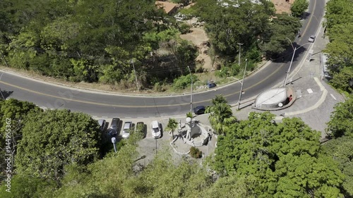 Drone orbits highway that runs along river as it pans up to reveal a forest photo