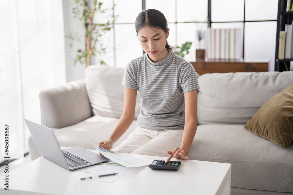 Asian Woman Pressing calculator for. financial planner remotely Personal finance at home. Asian Woman Pressing calculator for. financial planner remotely Personal finance at home.
