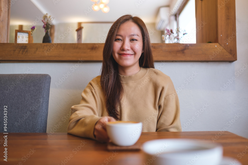 Portrait image of a young woman holding and drinking coffee with friend Portrait image of a young woman holding and drinking coffee with friend