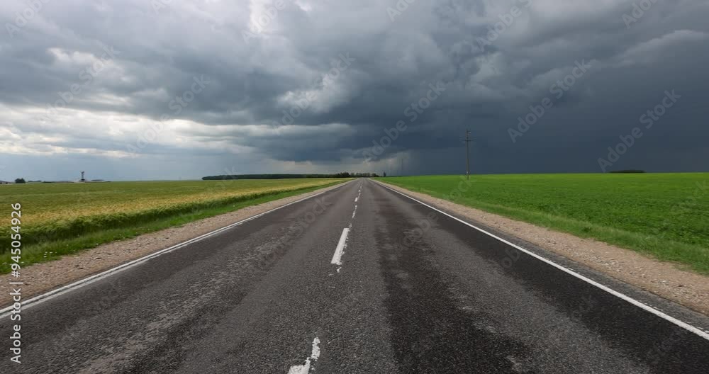 paved highway in cloudy weather, narrow rural paved road before a thunderstorm paved highway in cloudy weather, narrow rural paved road before a thunderstorm