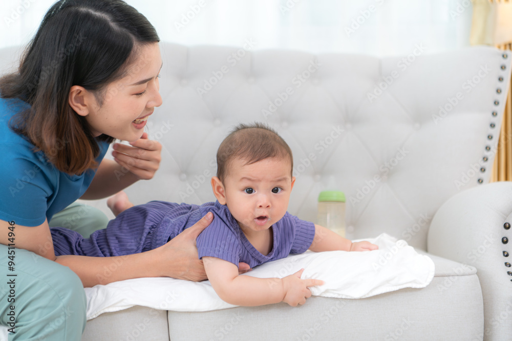 A mother lulls her little child to sleep on the sofa in the living room of the house