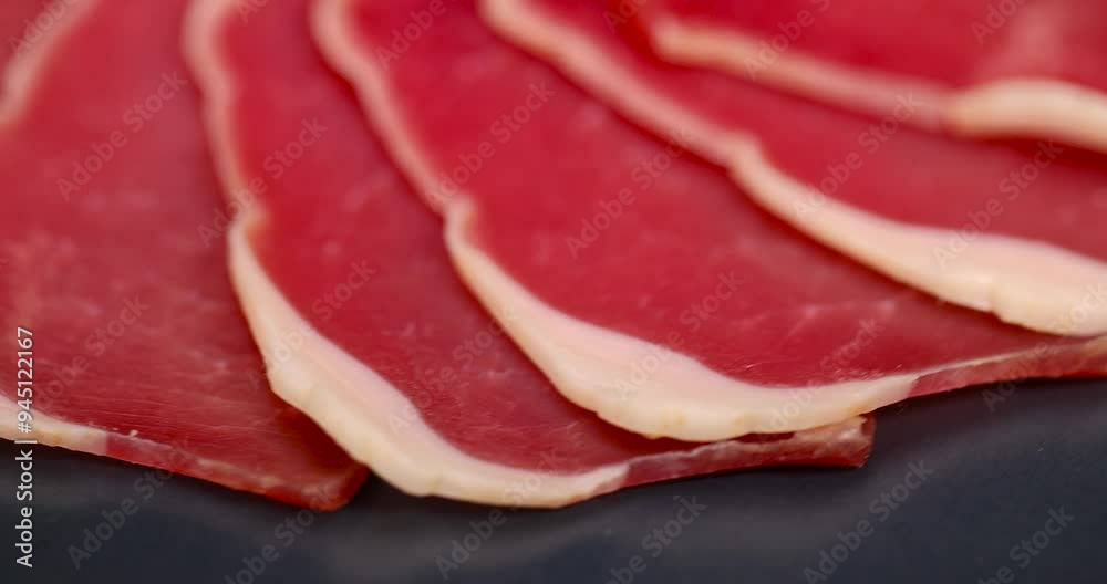 sliced ham with bacon on a board, thinly sliced pork ham from a fillet for serving a festive table