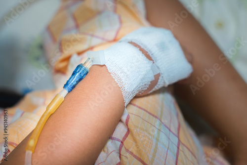 Close up child hand with tube of normal saline infusion at the hospital because it is influenza A. Hand of a patient in Hospital ward. Concept about treatment, emergency, medical, chemotherapy, sick. photo