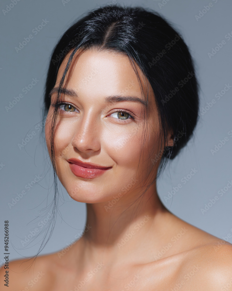 Fototapeta premium Smiling Woman with Radiant Skin and Natural Beauty Against Blue Background