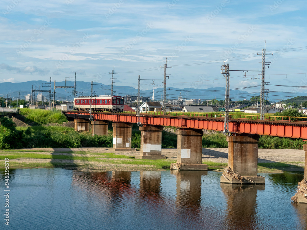夏の大和川を渡る近鉄道明寺線の電車