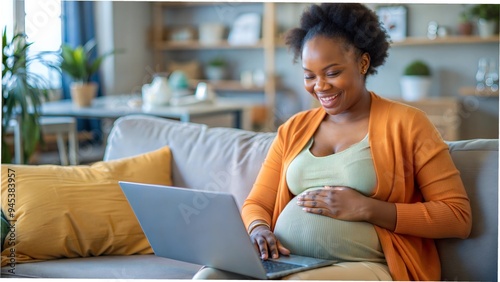 Happy pregnant black mom working remotely on laptop cradling baby bump. Inclusive flexible remote workplace. Expectant mother on team video call handover before maternity leave