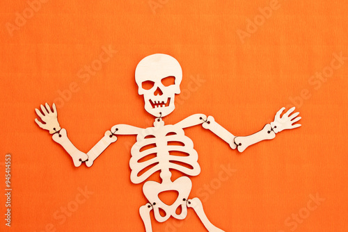 Wooden halloween skeleton on orange background