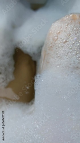 Woman taking a bath. Women's feet in bubble bath. Rest, relaxation, washing, hygiene, cleanliness, self-care. photo