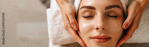 Relaxing facial treatment session at a serene spa, showcasing a woman enjoying rejuvenating skincare in a calming environment. With copy space for text. Wide web banner.