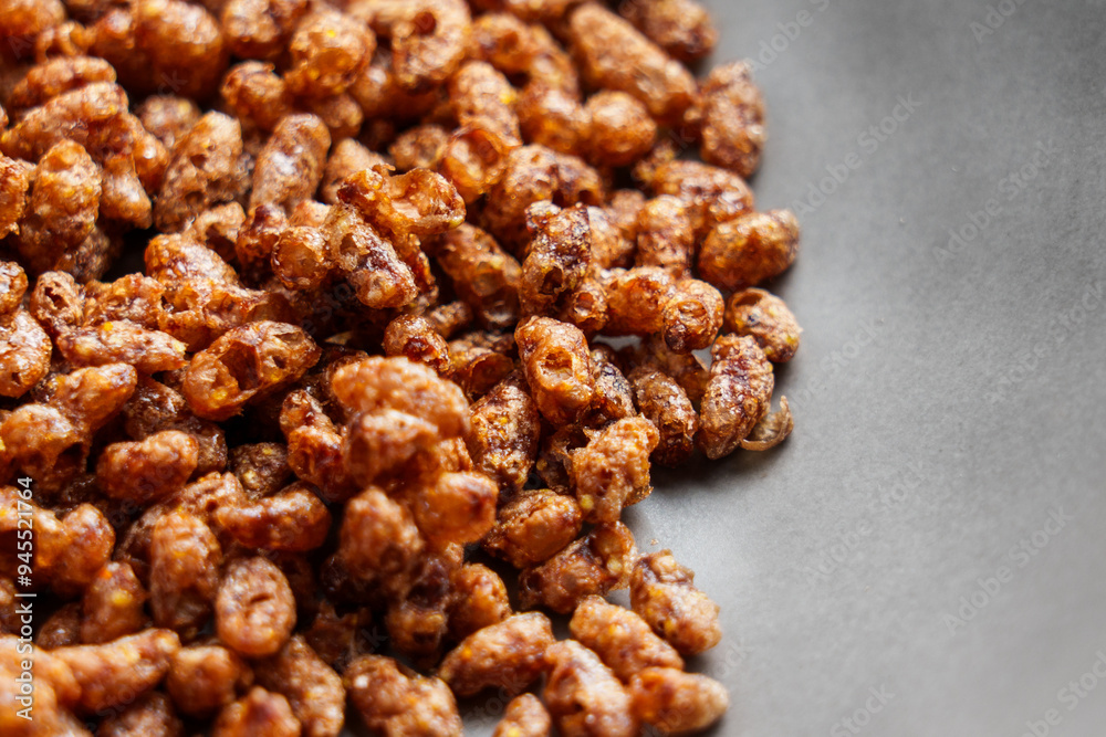 Chocolate crispy rice breakfast cereal flakes scattered in a black plate close up