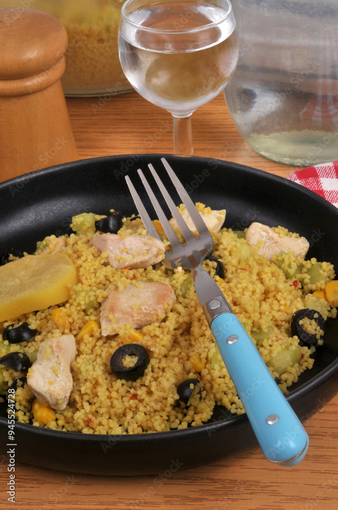 Assiette de semoule estivale avec des morceaux de poulet, des olives ...