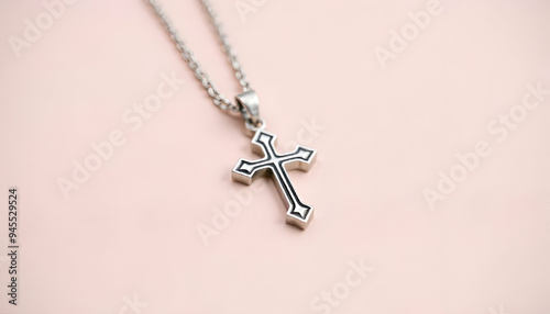 A silver cross pendant on a chain against a soft background