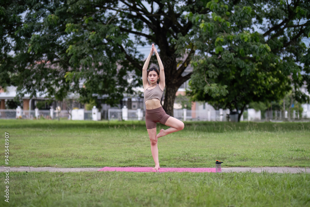 Young Woman Balancing in Tree Pose on Yoga Mat Outdoors Young Woman Balancing in Tree Pose on Yoga Mat Outdoors